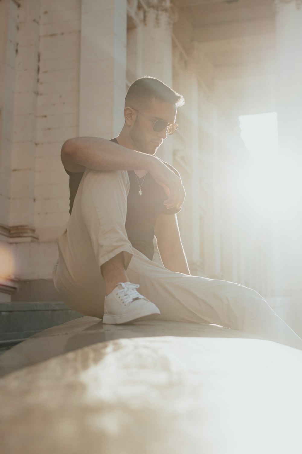 a man sitting on a ledge with his arms crossed