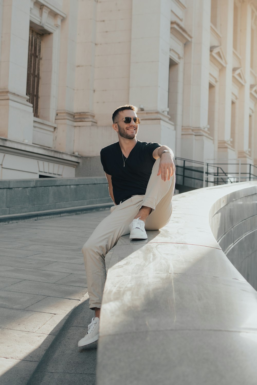 a man sitting on a ledge in front of a building