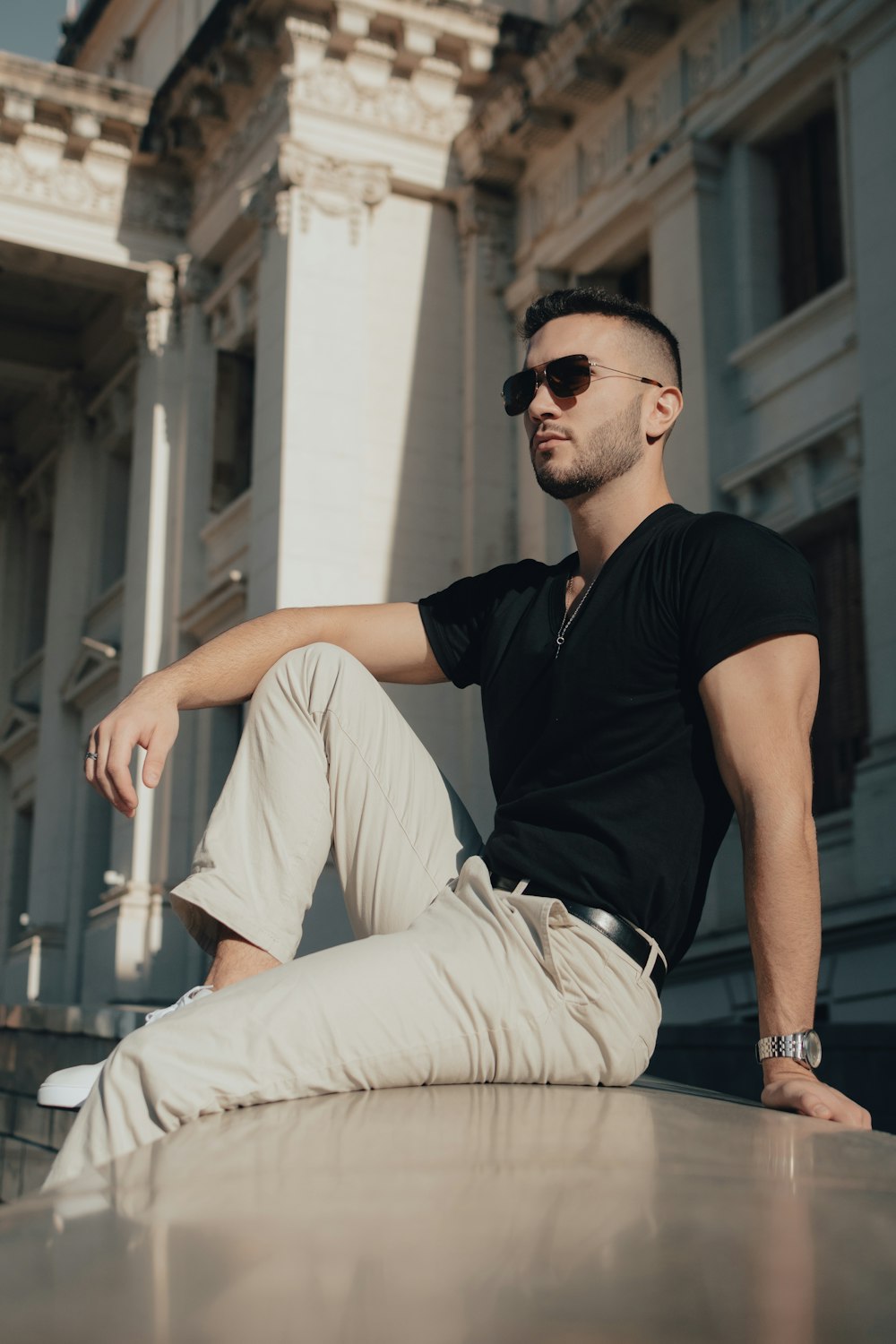 a man sitting on a ledge in front of a building