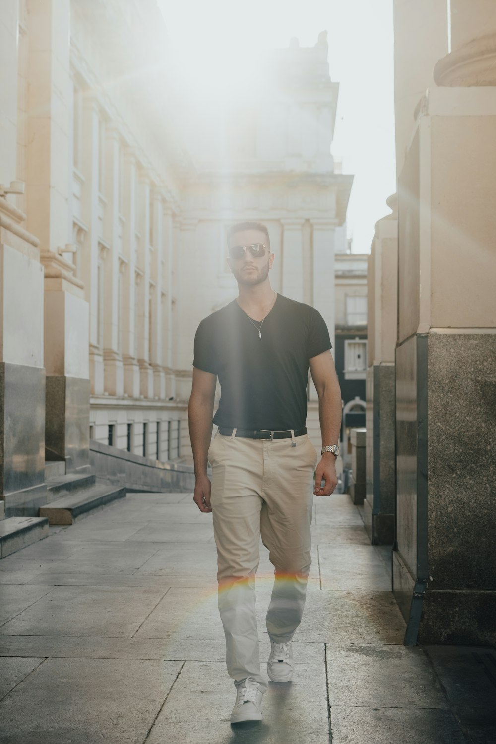 a man walking down a sidewalk in front of a building