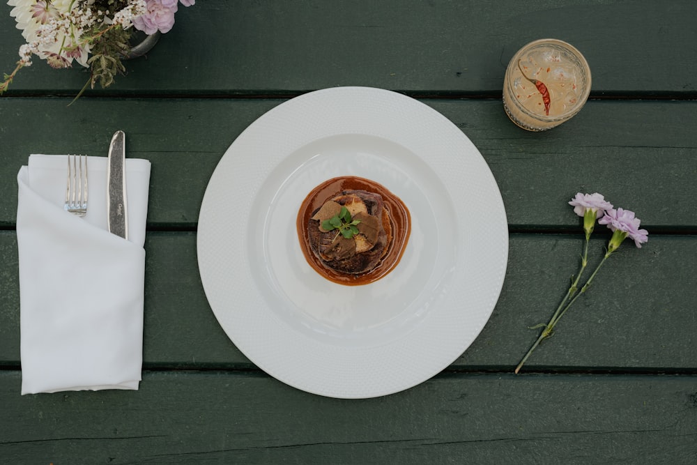 ein Teller mit Essen auf einem Tisch mit einer Serviette und Blumen