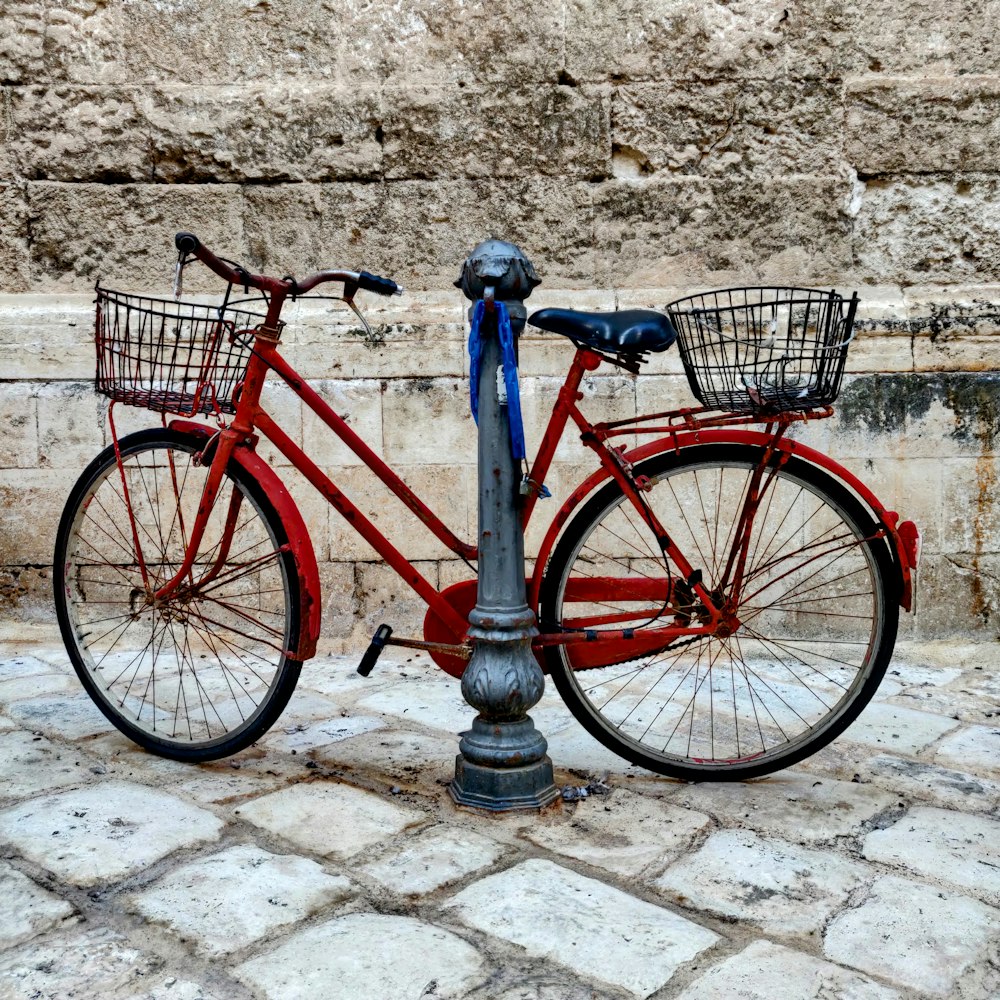 a red bicycle parked next to a parking meter