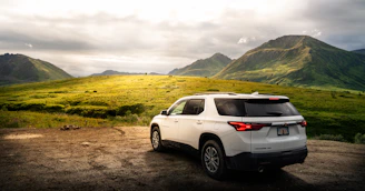 a white suv parked on a dirt road