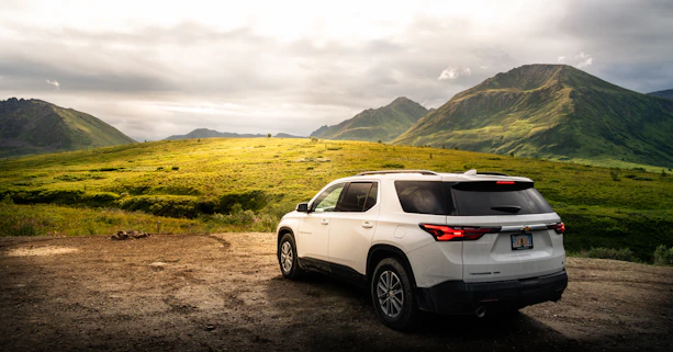 a white suv parked on a dirt road