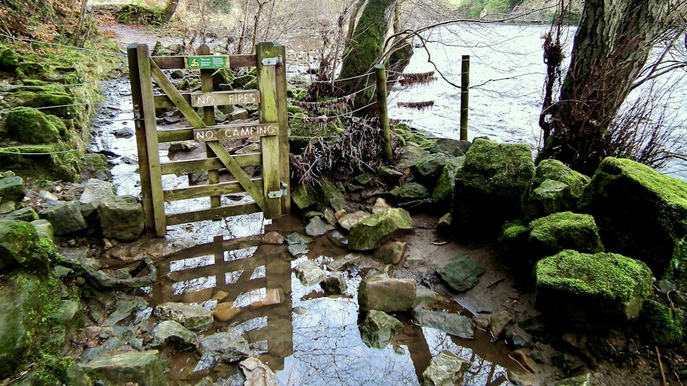 a wooden gate in the middle of a stream