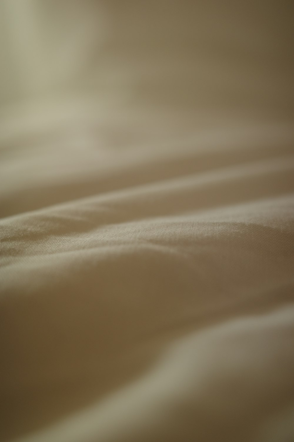 a blurry image of a bed with white sheets