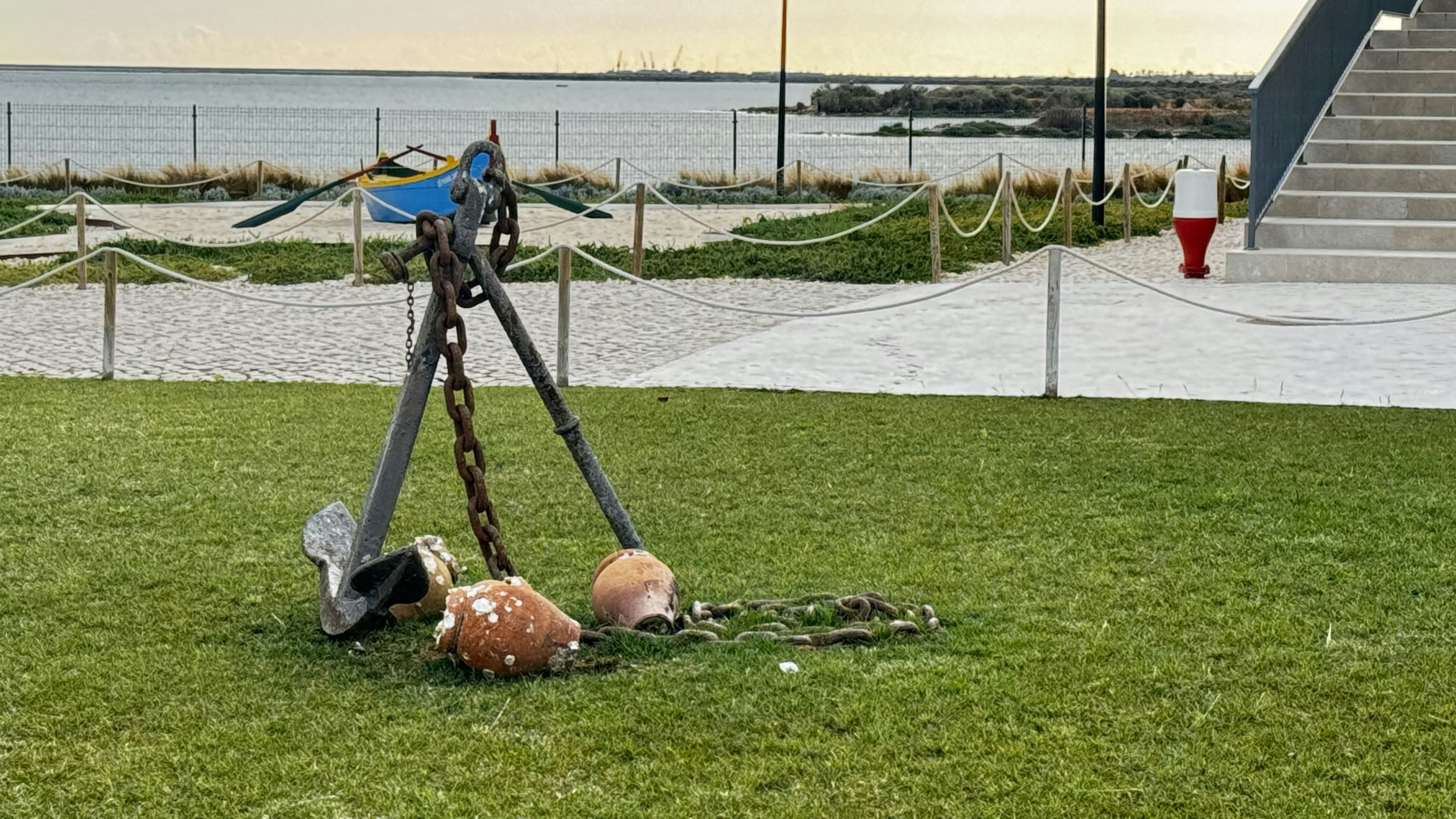a sculpture in the grass with a bird on top of it