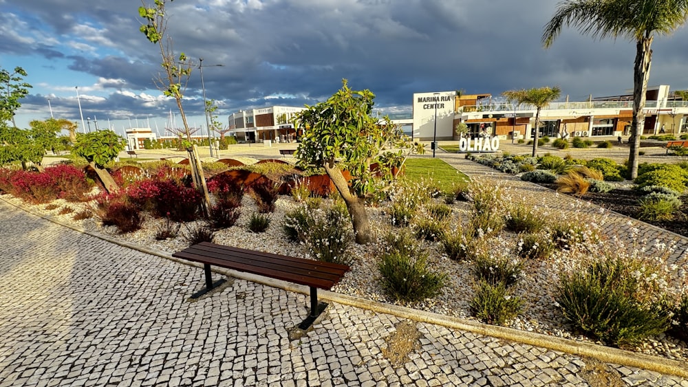 a wooden bench sitting on top of a cobblestone road