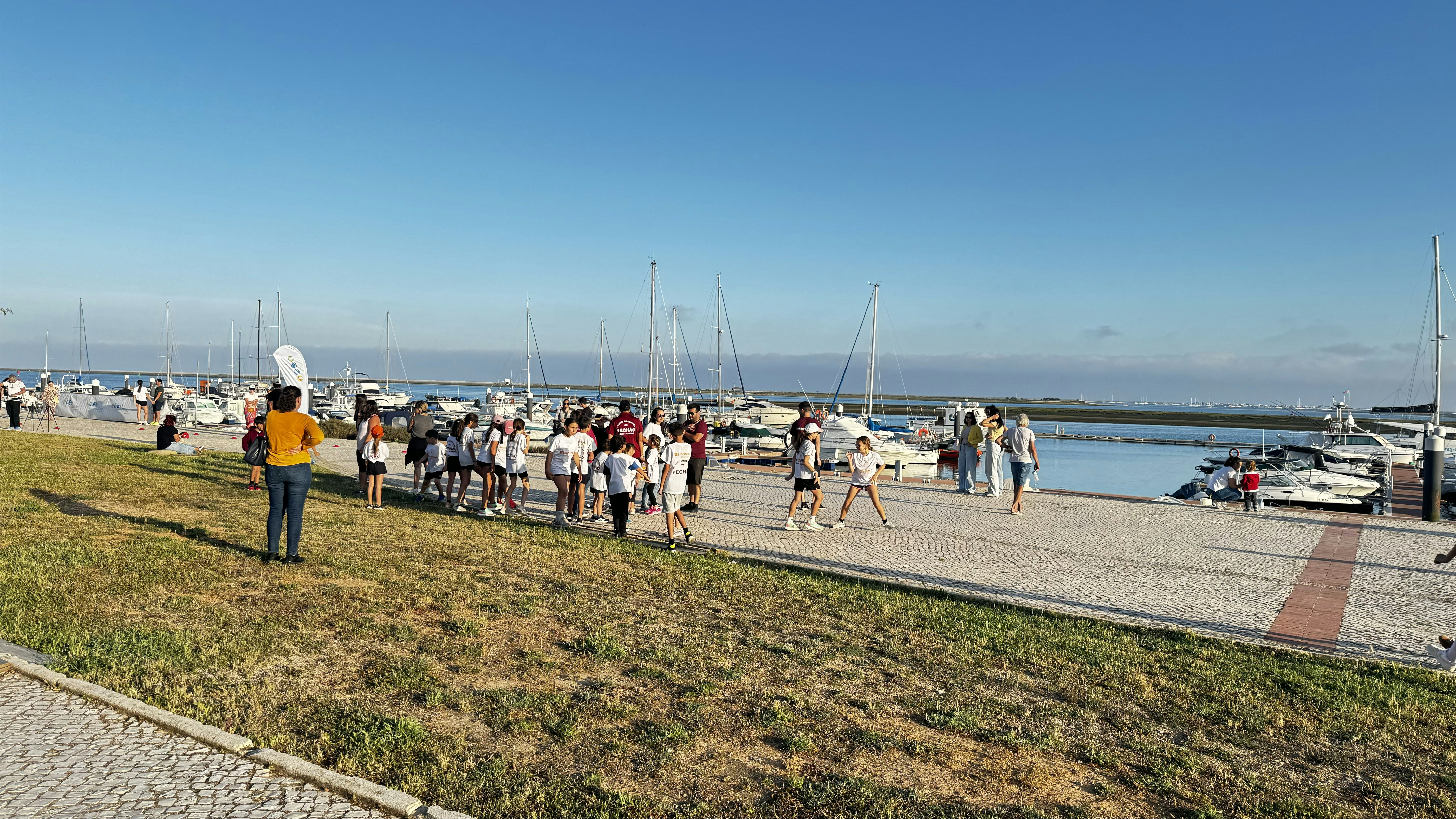a group of people walking along a beach next to a body of water