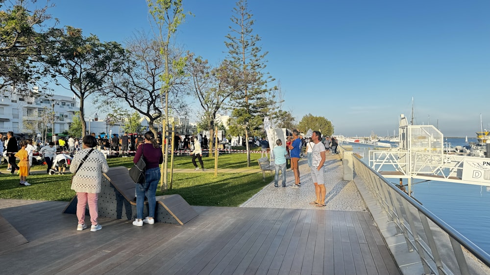 a group of people standing on top of a wooden walkway