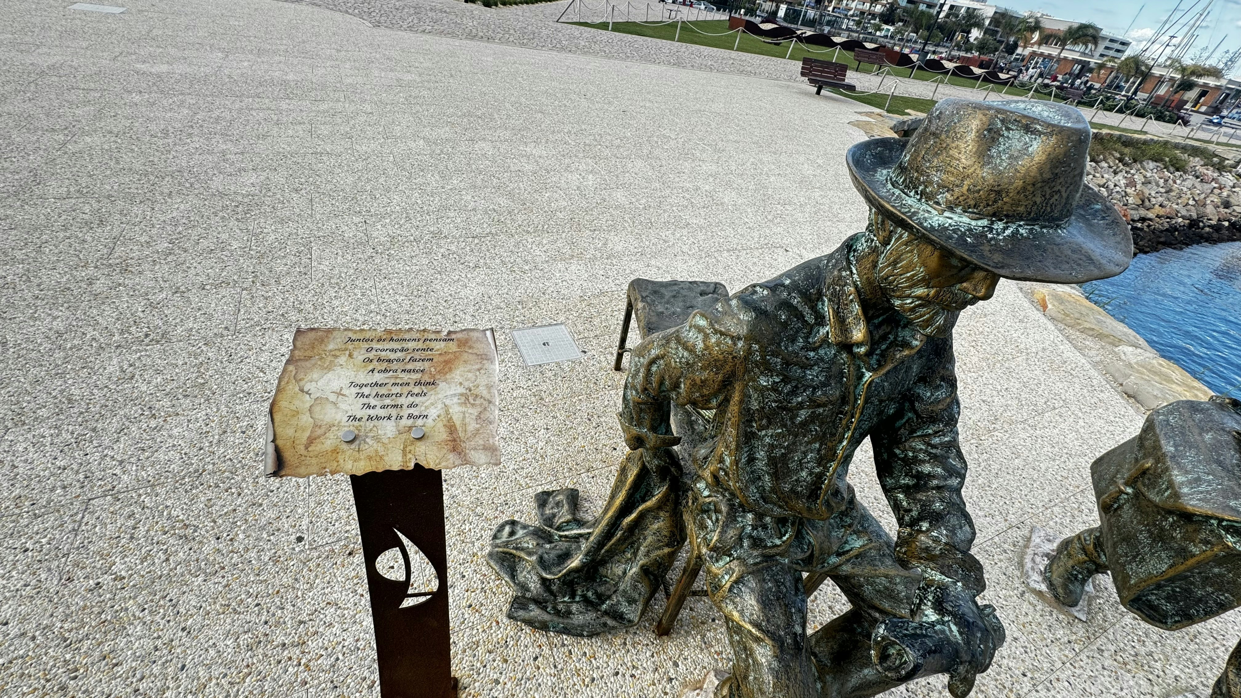 a statue of a man sitting next to a sign