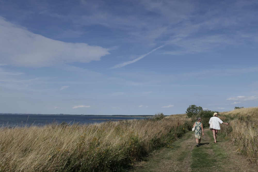 a man and a woman are walking down a path