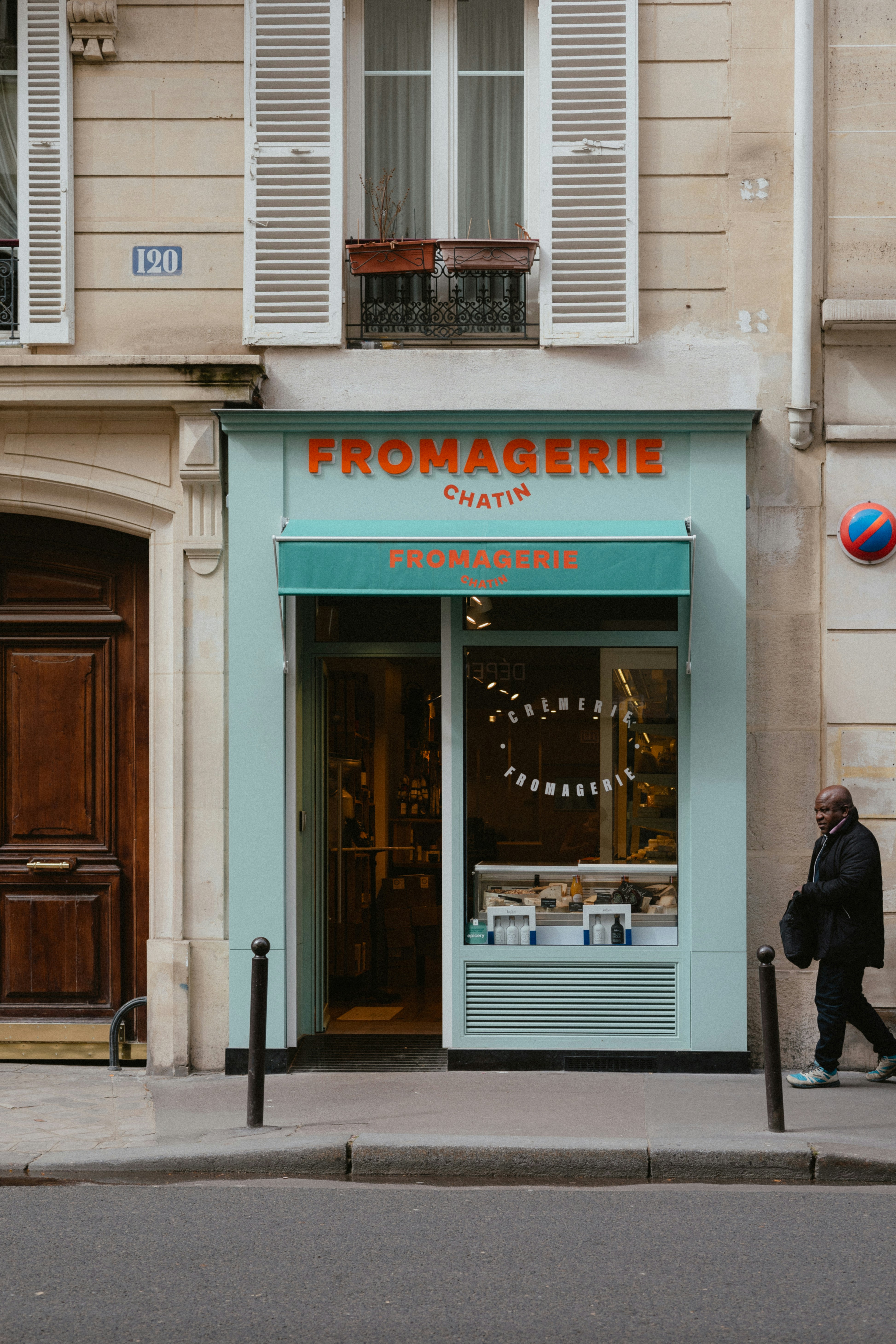 a man walking past a store front on a city street