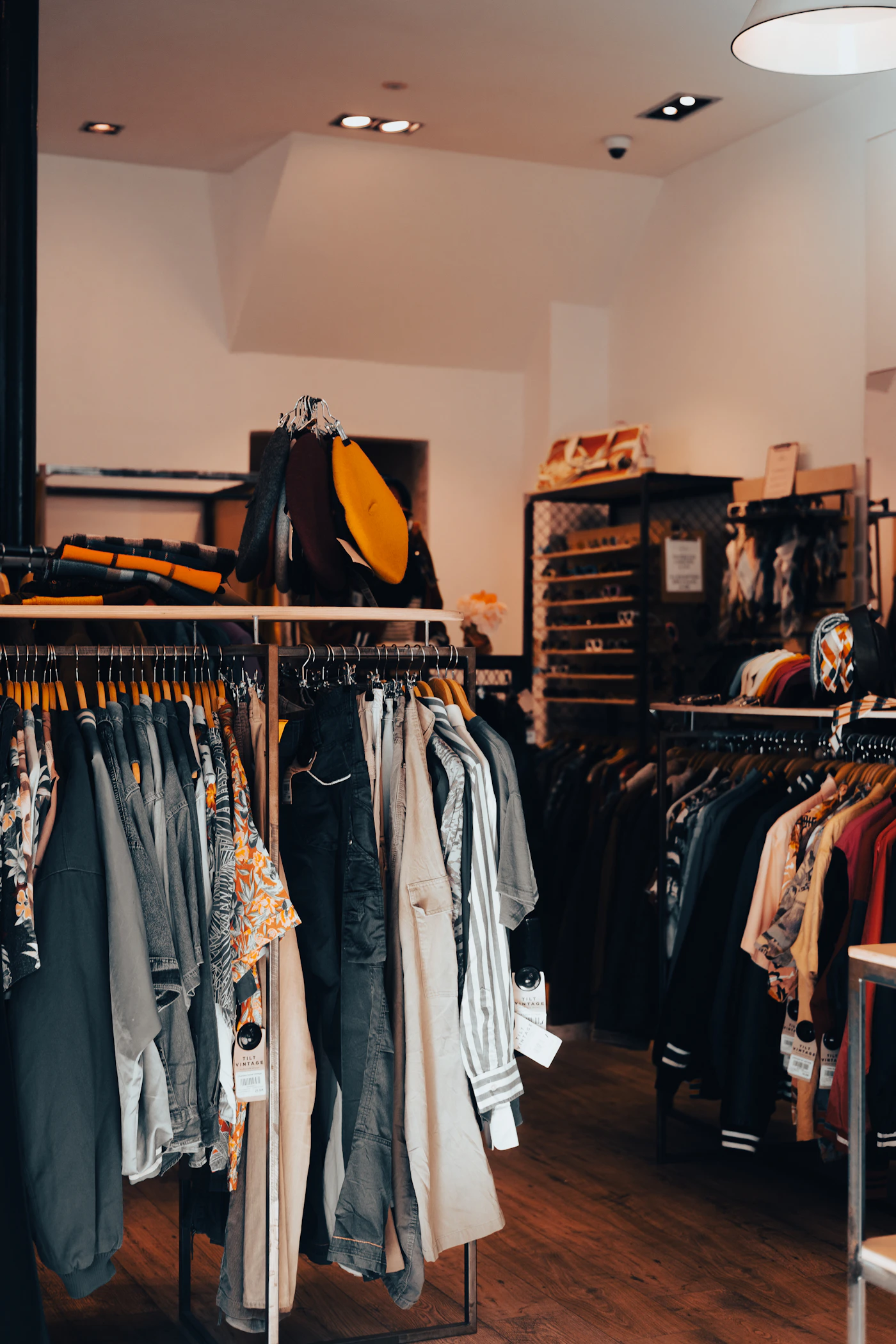 Portants de vêtements de seconde main dans une boutique chaleureuse
