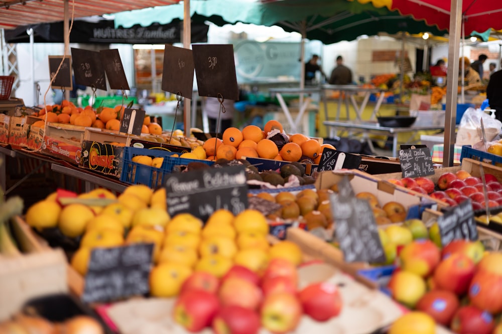 a fruit stand with lots of oranges and apples