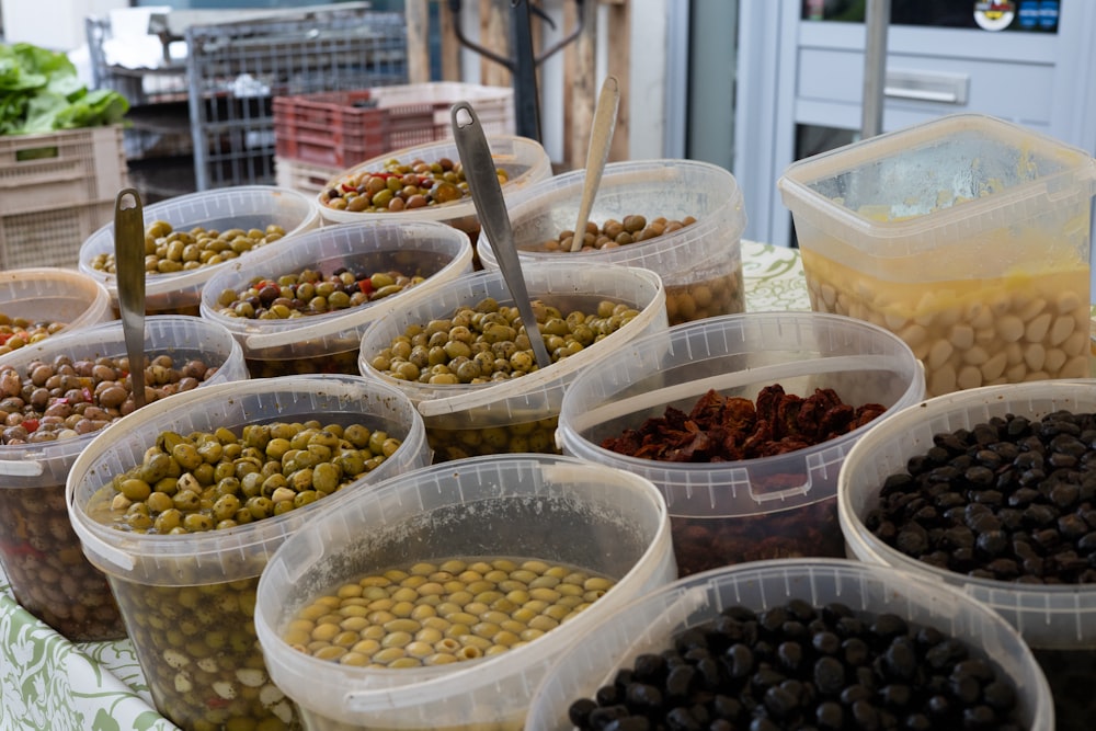 a table topped with lots of plastic containers filled with food