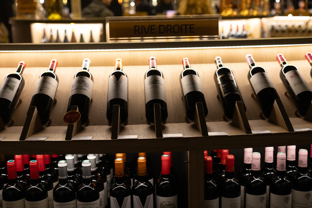 Wine bottles displayed on a lit shop shelf