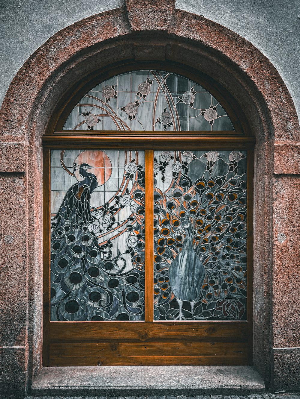 eine dekorative Glastür mit einem Pfau darauf