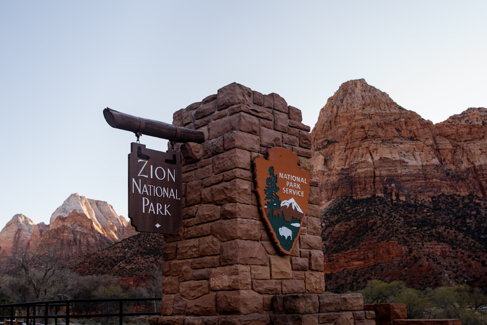 Un panneau indiquant un parc national avec des montagnes en arrière-plan