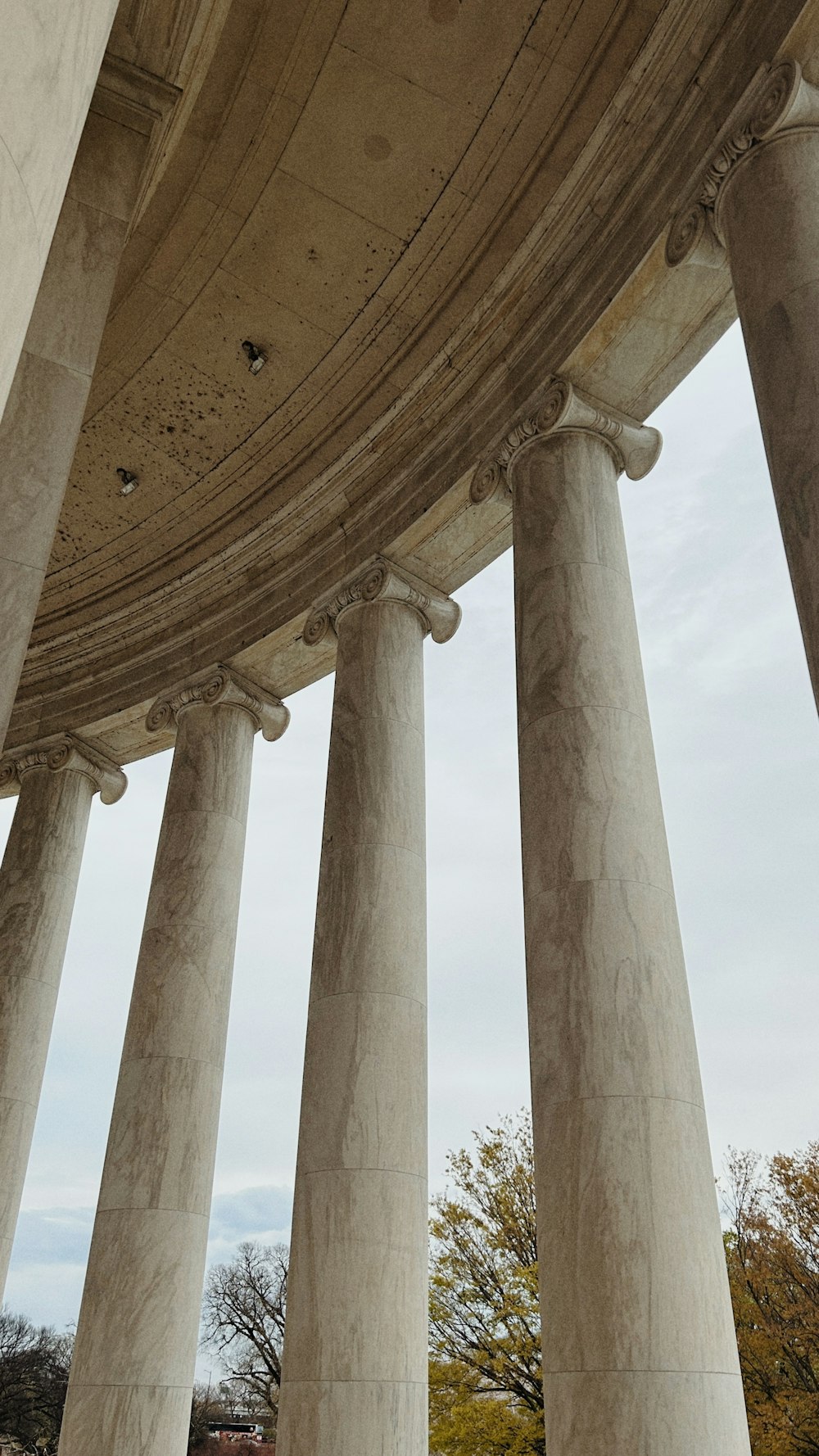 a person sitting on a bench in front of some pillars