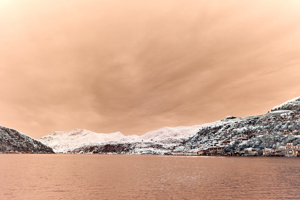 a large body of water surrounded by snow covered mountains