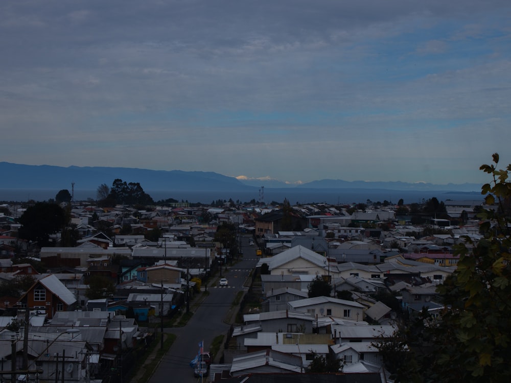 a view of a city with houses and mountains in the background