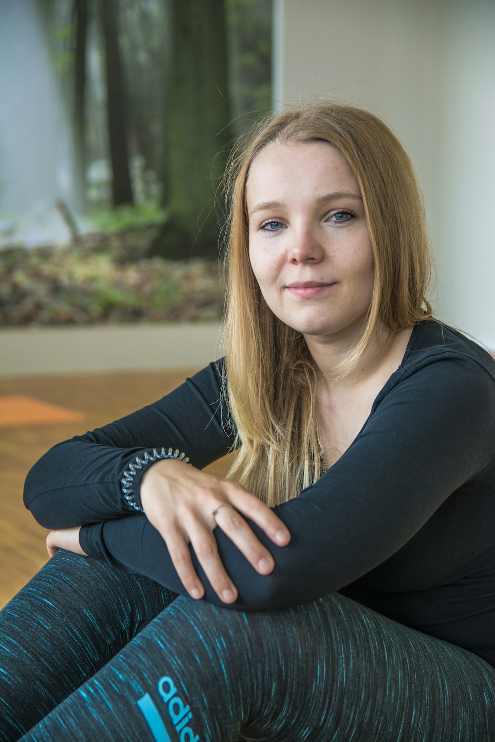 a woman sitting on the floor with her legs crossed