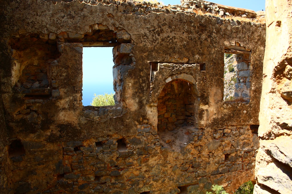 a stone building with two windows and a view of the ocean