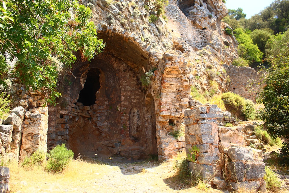 an old stone building with a cave in the middle of it