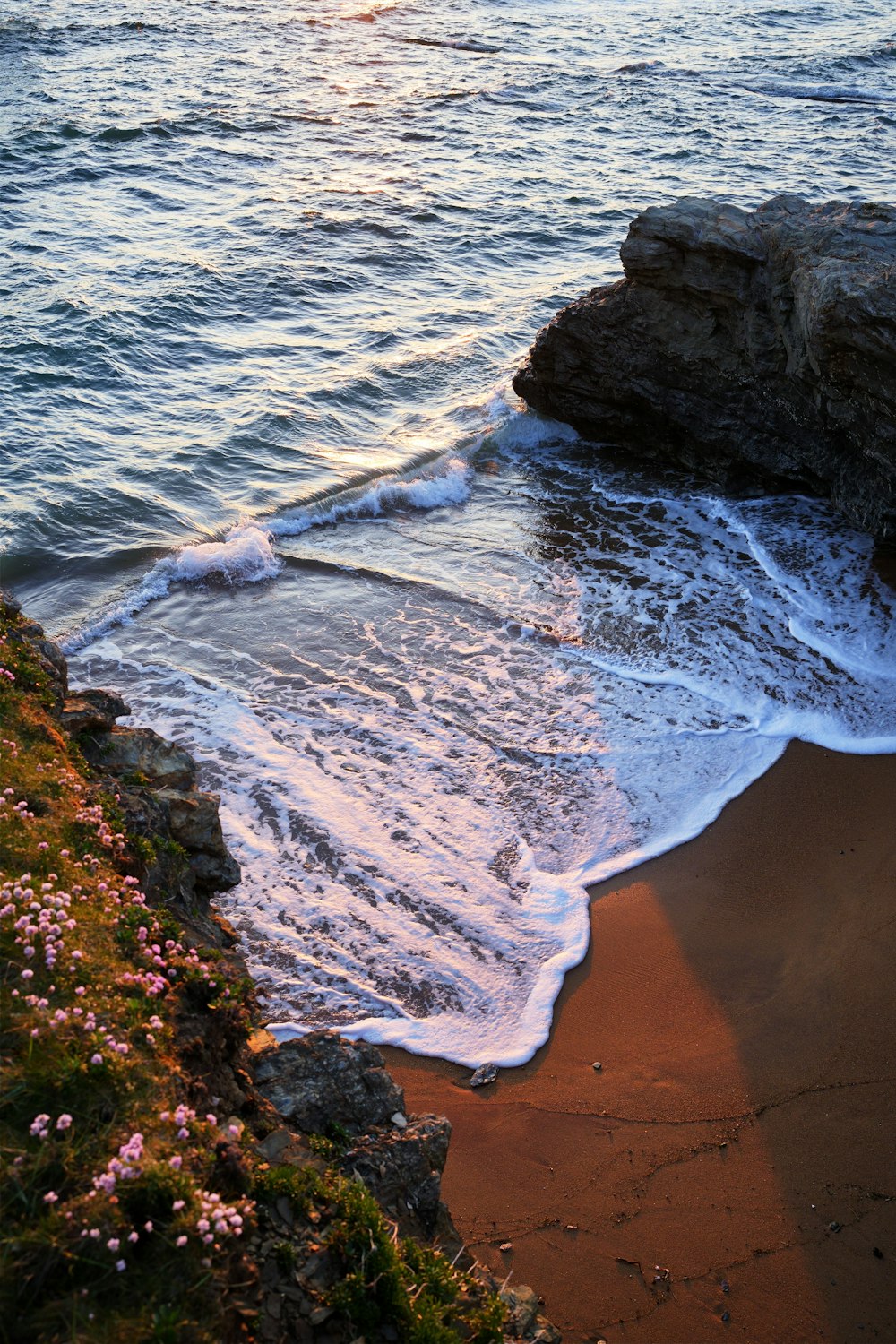 Le soleil se couche sur l’eau de la plage