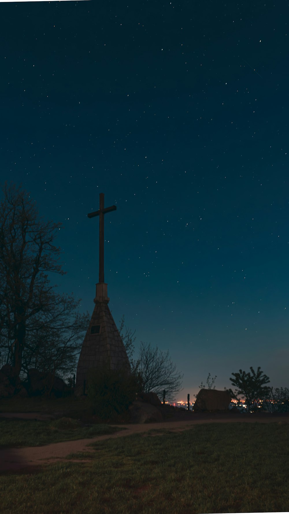 una cruz en la cima de una colina por la noche