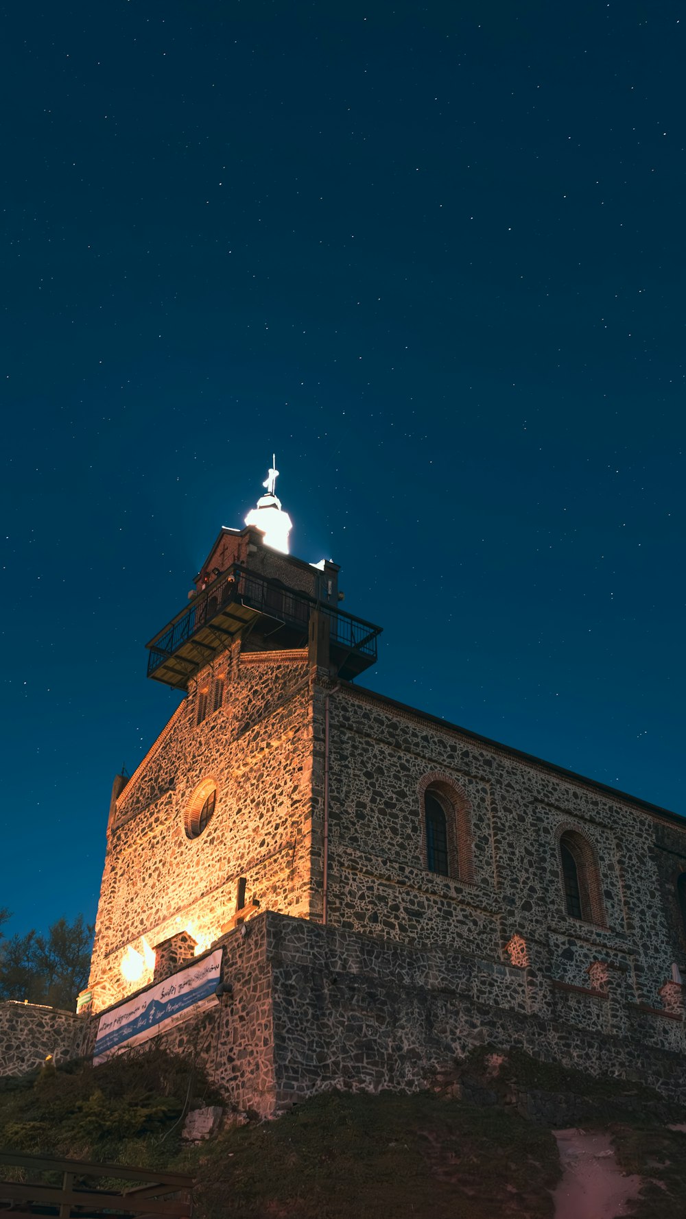 a stone building with a light on top of it