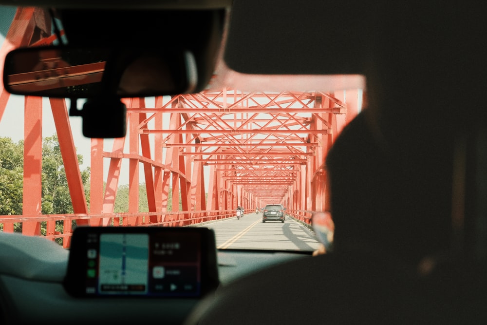 a car driving down a road next to a bridge