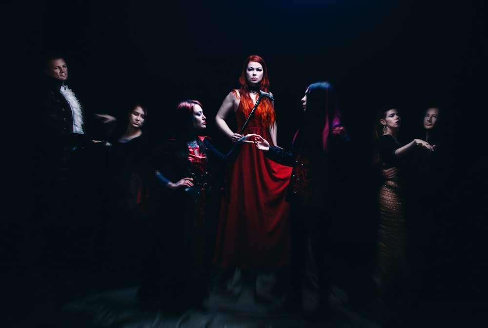 una mujer con un vestido rojo rodeada de otras personas