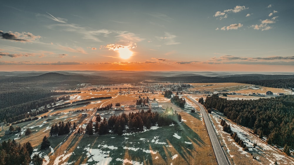 the sun is setting over a rural area