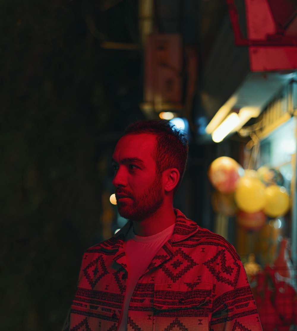 a man standing in front of a store at night