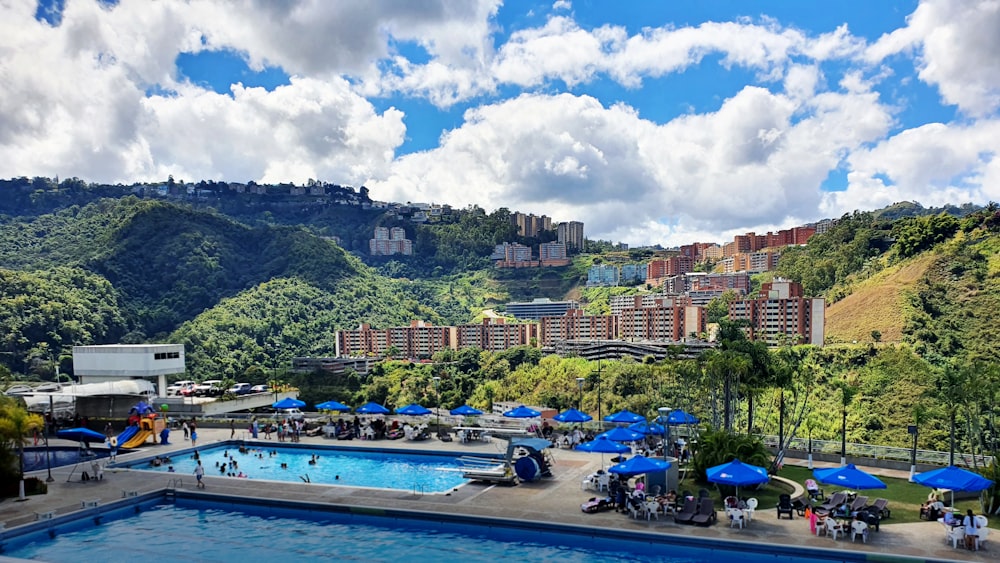 a large swimming pool surrounded by a lush green hillside