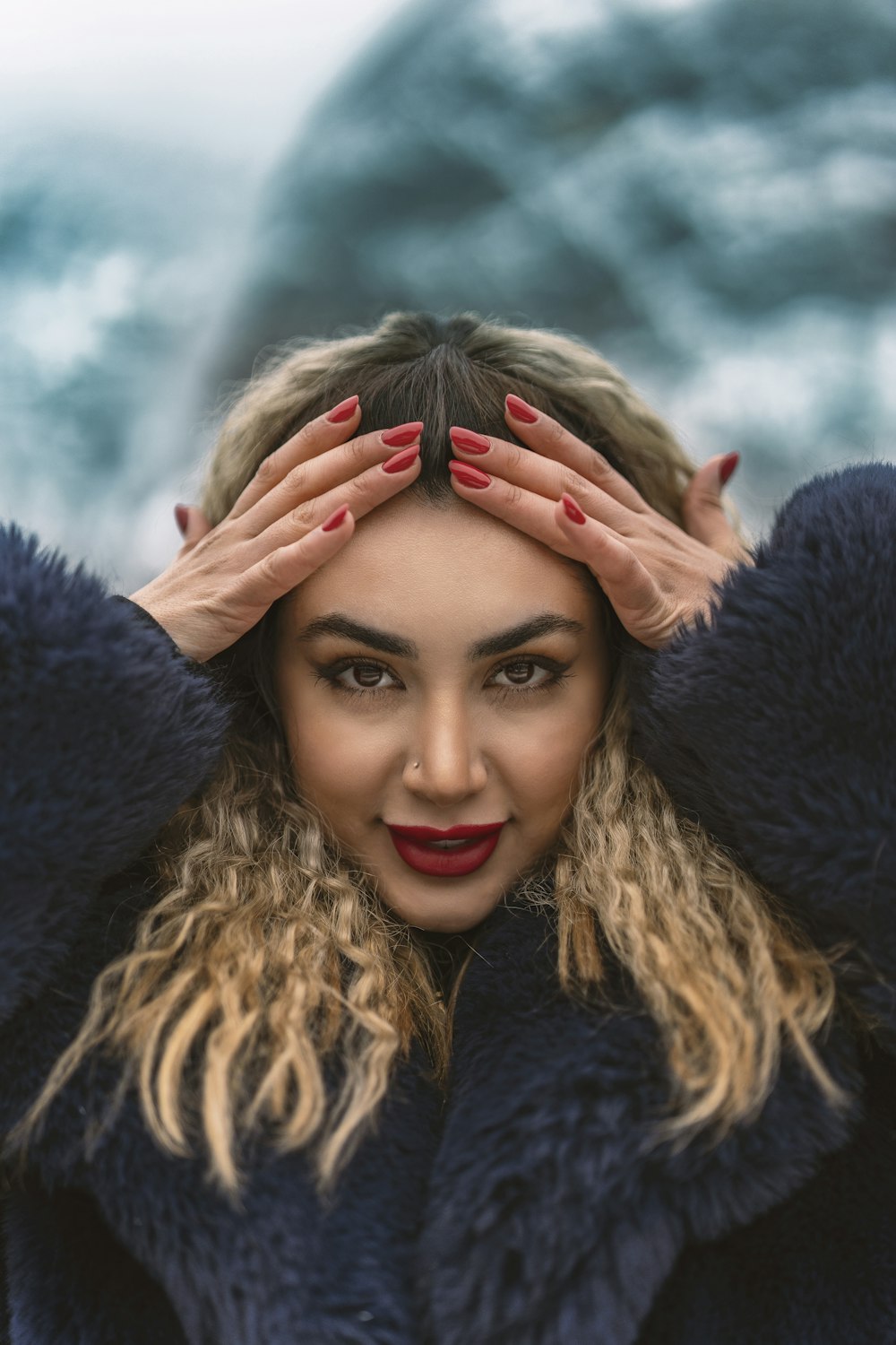 a woman in a fur coat with her hands on her head