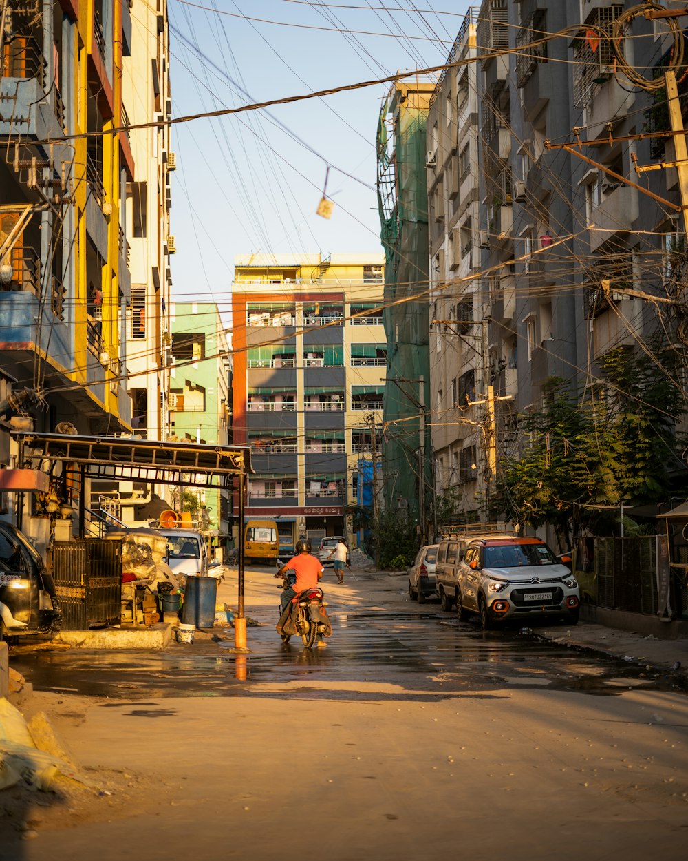 a man riding a bike down a street next to tall buildings