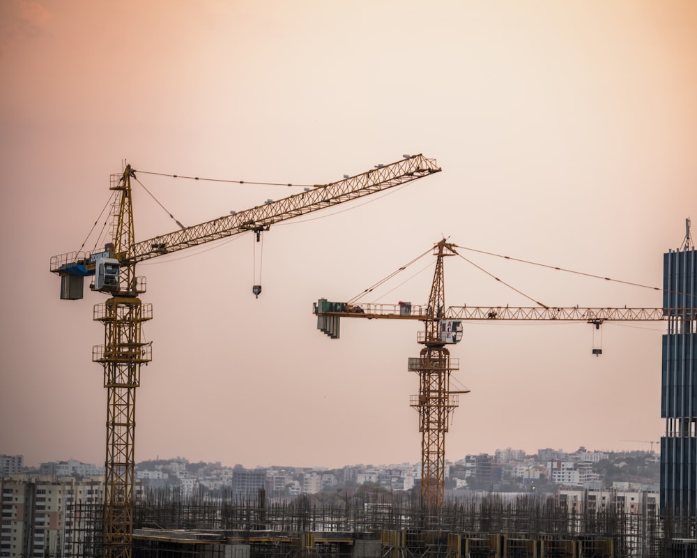 a group of cranes that are next to a building