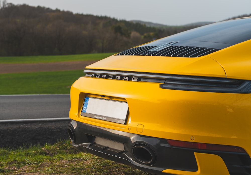 a yellow sports car parked on the side of the road