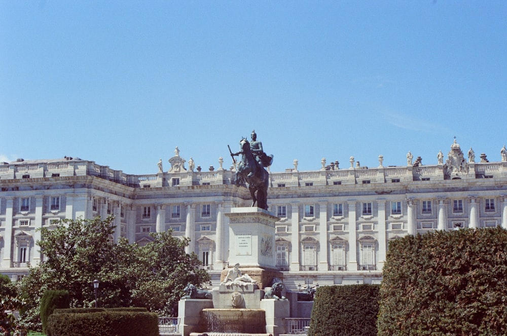 a statue of a man on a horse in front of a building