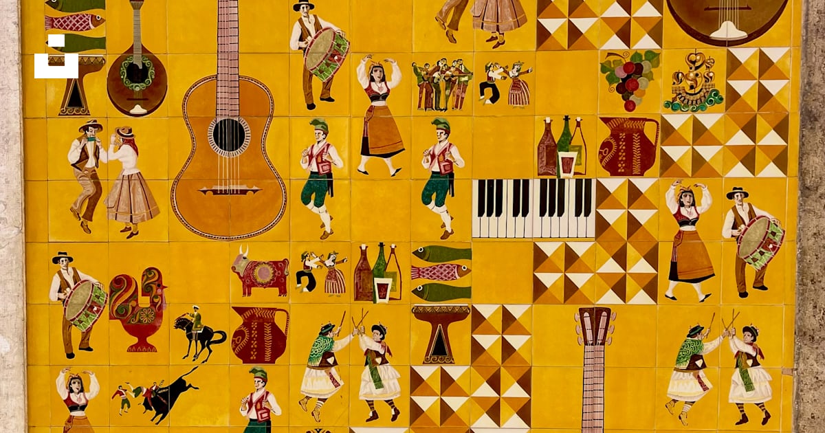 A yellow tile wall with a guitar and musical instruments on it photo ...
