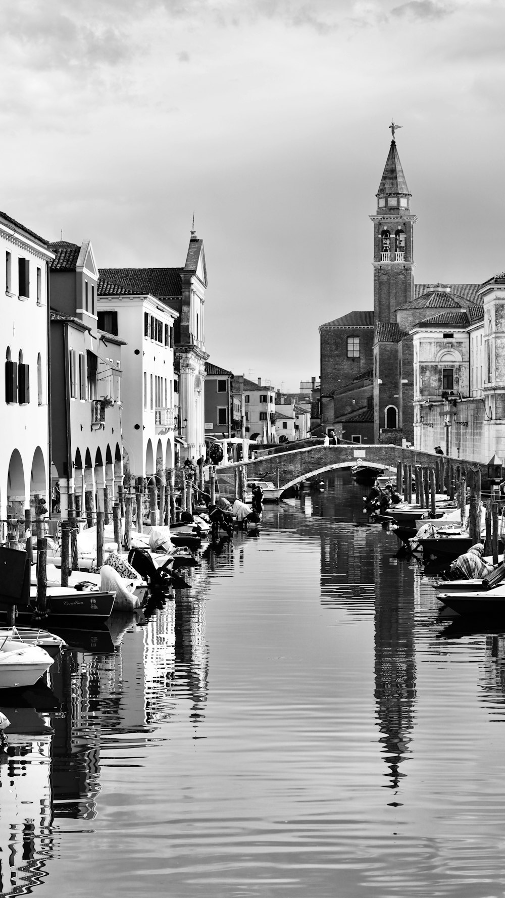 a black and white photo of a canal in venice