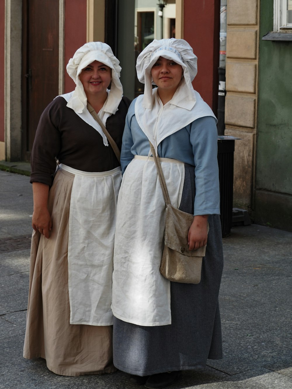 two women standing next to each other on a street