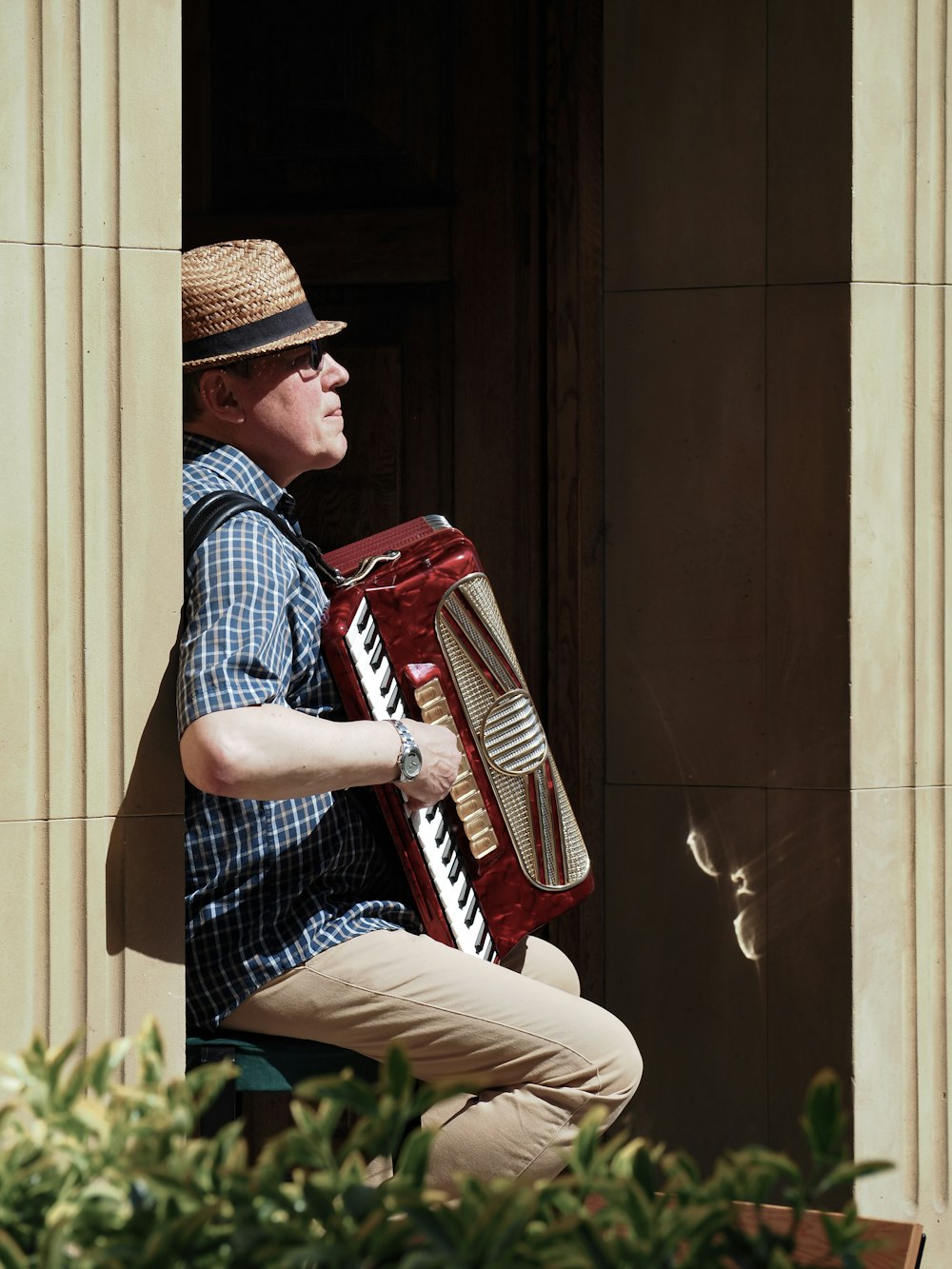 a man sitting on a ledge playing an accordion