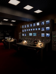 a control room with multiple monitors and lights