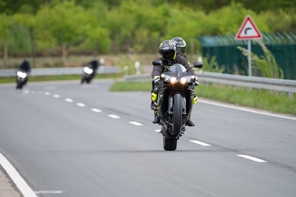 a group of people riding motorcycles down a road