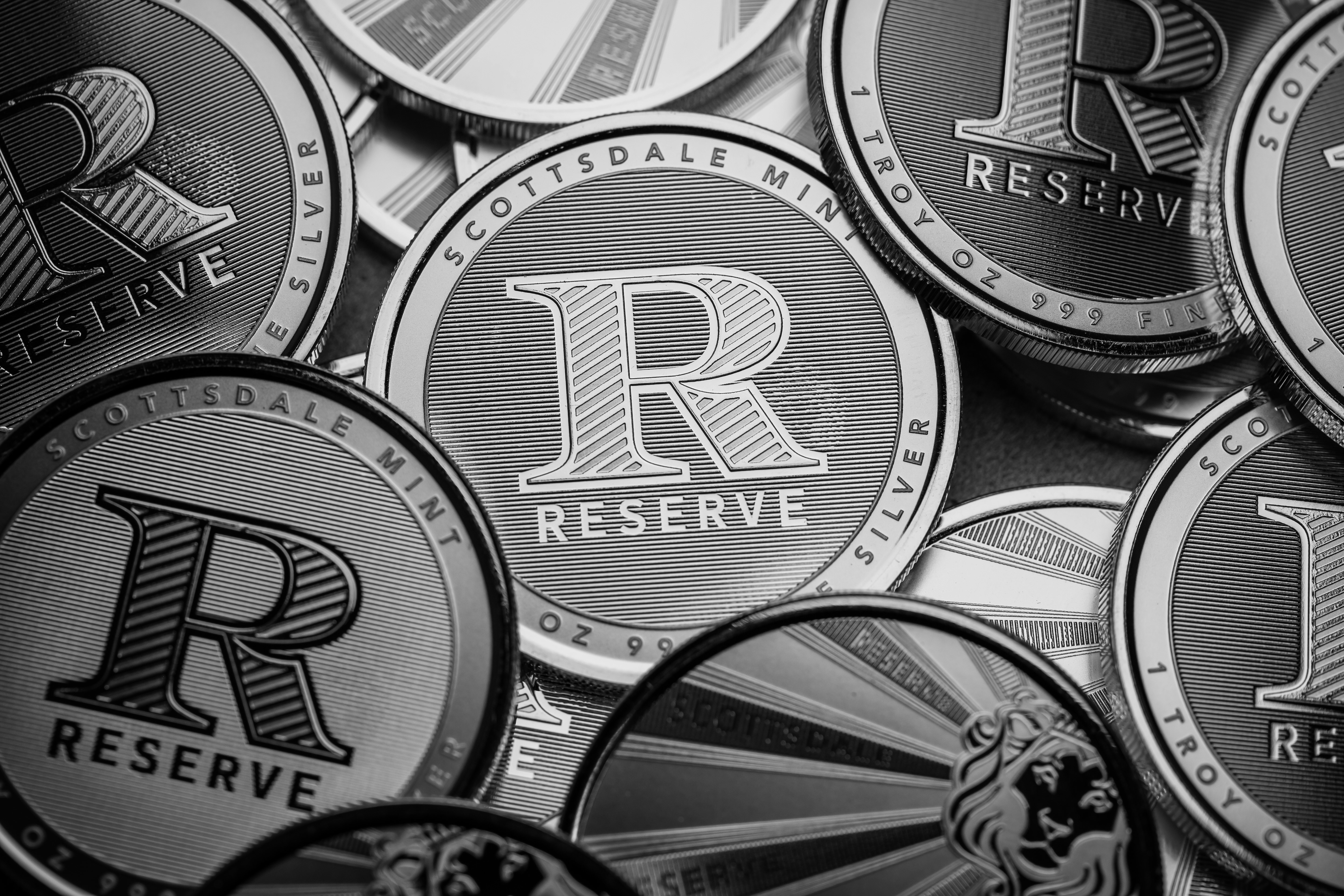 Scottsdale Mint Reserve Bullion rounds sitting on a textured table.