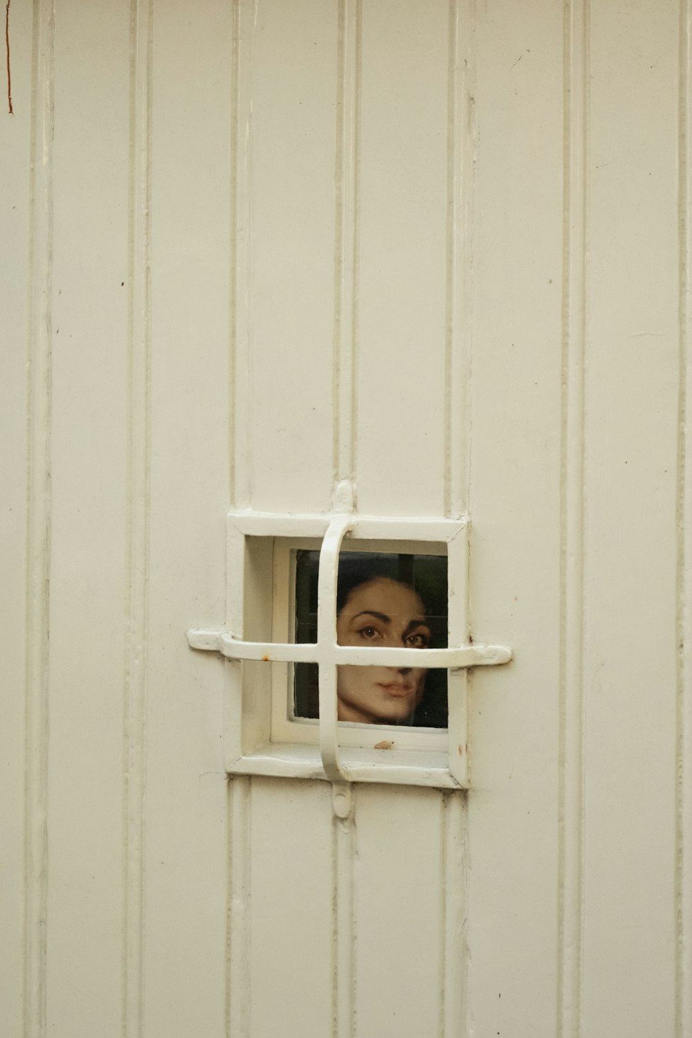 El rostro de una mujer se ve a través de una ventana